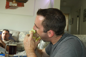 Sean attacks his piece of giant burger