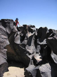 Jpy climbing over lava at Fossil Falls