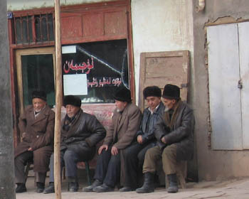 men sitting outside a shop