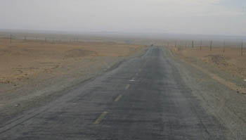desolate road across the edge of the Taklimakan Desert